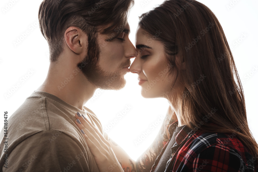 Lovely couple. Side view of man kissing girlfriend to nose. Lovely couple. Side view of man kissing girlfriend to nose.
