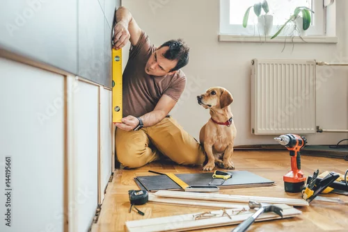 Obraz Mężczyzna i jego pies robi remontowej pracy w domu