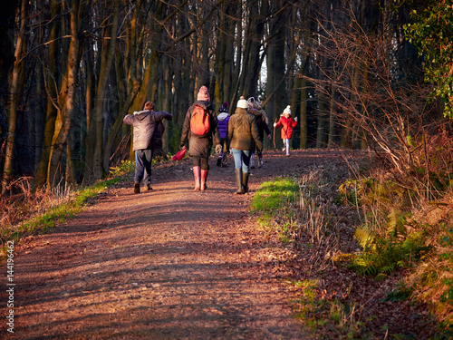 Obraz na płótnie A family out for an evening woodland walk at sunset. w salonie