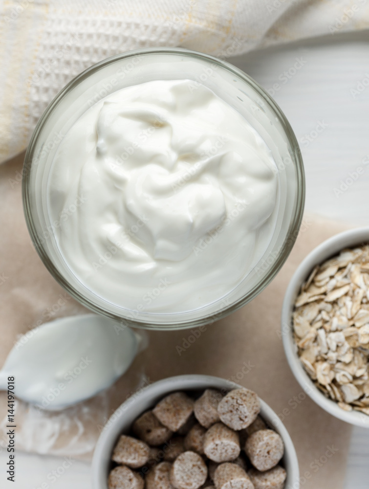 White yogurt in glass on a wooden table top view, vertical White yogurt in glass on a wooden table top view, vertical