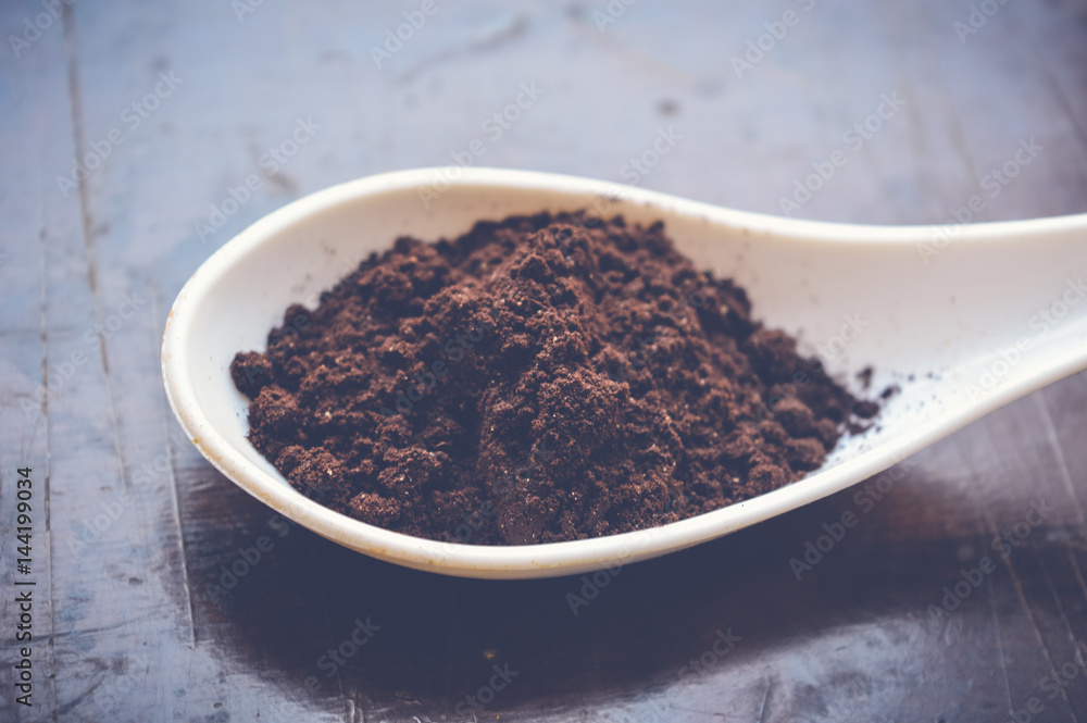 coffee powder on white spoon on wooden table coffee powder on white spoon on wooden table