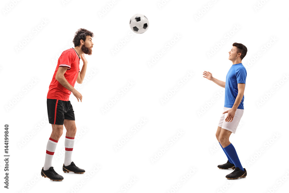Son and a father dressed in jerseys playing with football