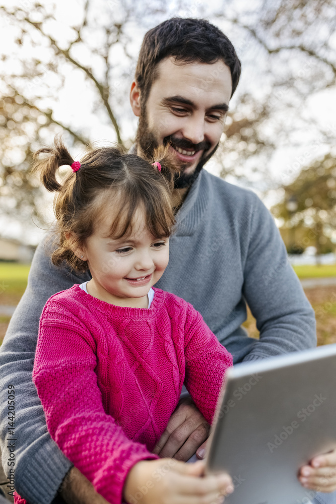 Father and little daughter taking selfie with tablet in autumnal park Father and little daughter taking selfie with tablet in autumnal park