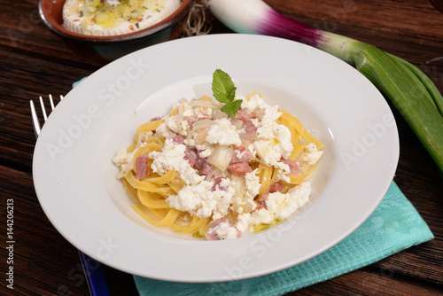 Dish of pasta noodles with cottage cheese bacon and onion shallot 