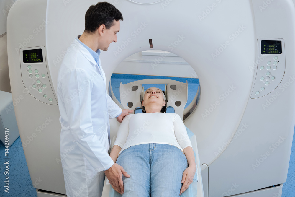 Pleasant handsome oncologist standing near his patient Pleasant handsome oncologist standing near his patient
