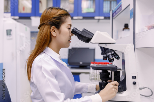 Scientist using a microscope in a laboratory.