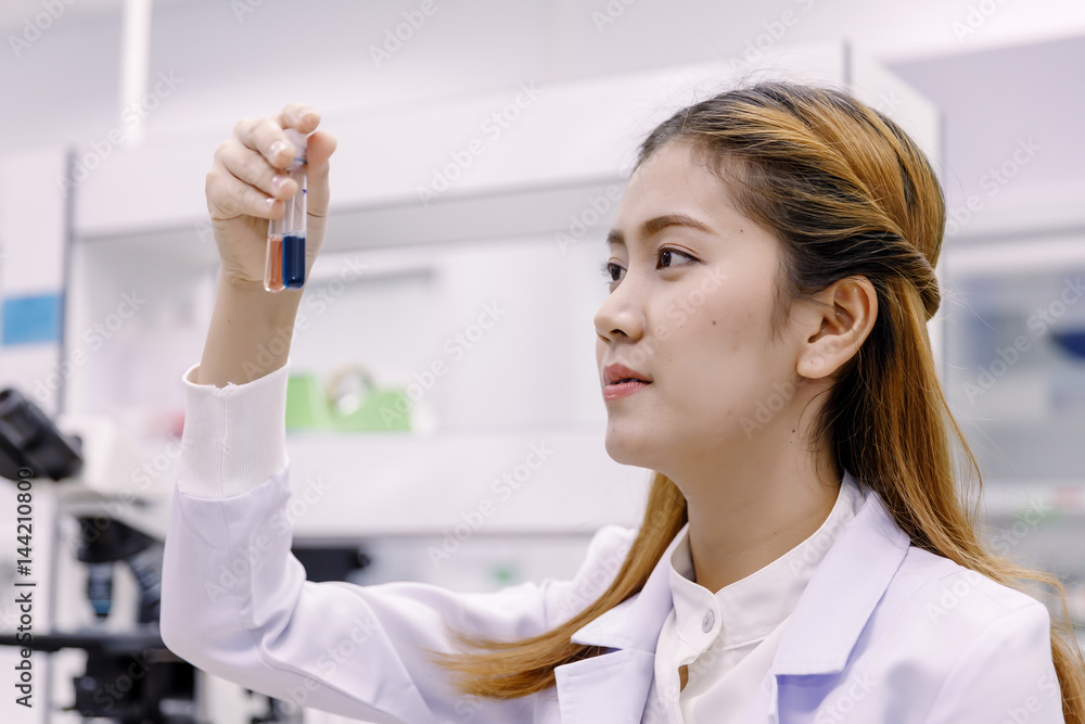 Young Asian researcher looking at the flask in the science laboratory Young Asian researcher looking at the flask in the science laboratory