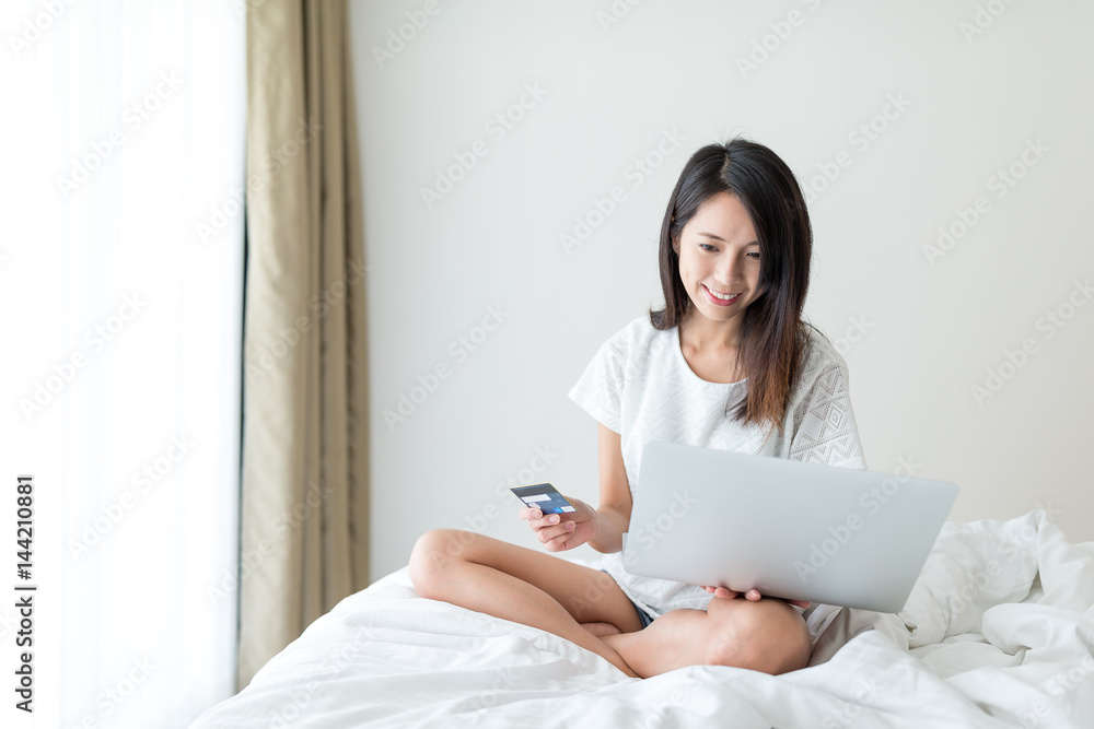 Woman shopping online with laptop computer and credit card Woman shopping online with laptop computer and credit card