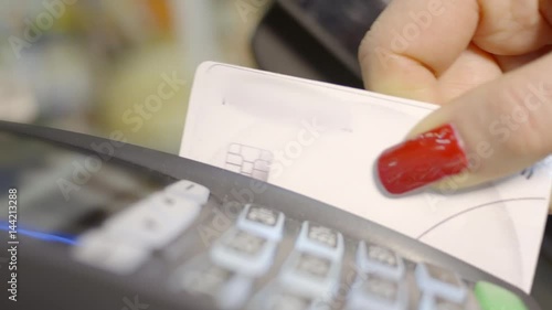 Close-up of woman hand holding plastic card in payment machine