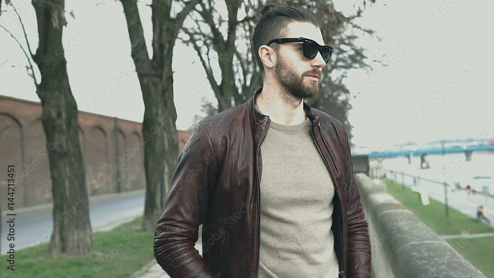 Handsome man in leather jacket standing on boulevards and smiling to the camera, steadycam shot
Handsome man in leather jacket standing on boulevards and smiling to the camera, steadycam shot