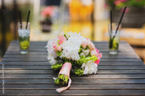 Bride bouquet on a table with coctails