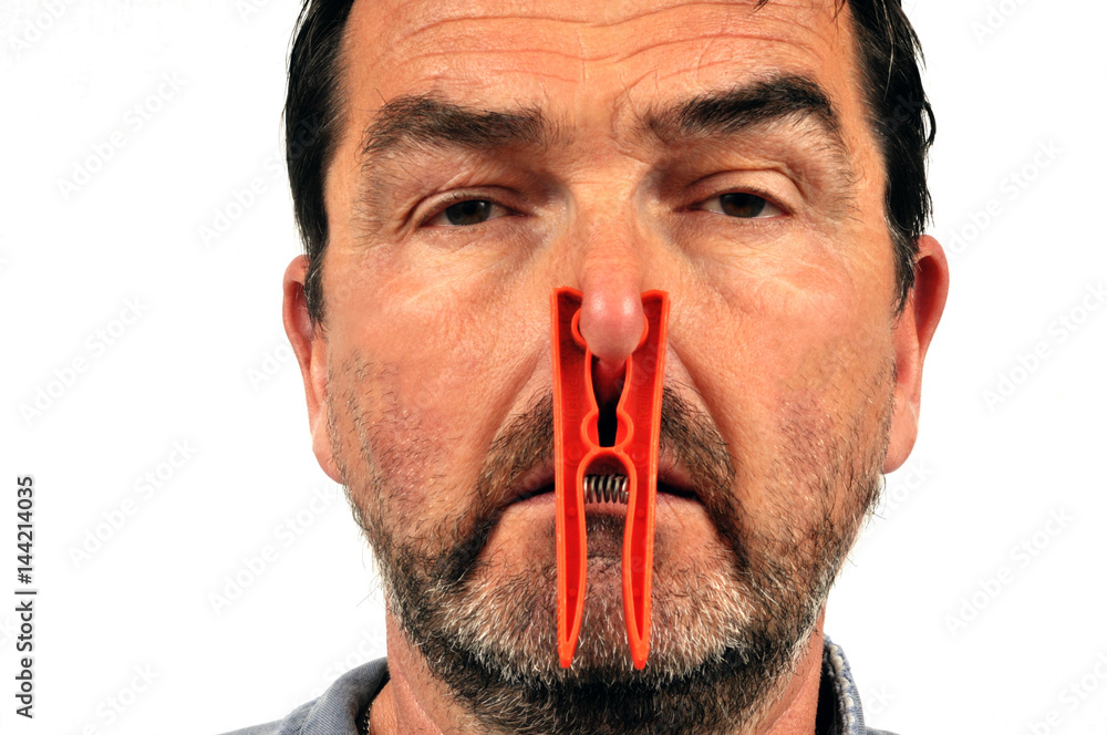 Homme avec une pince à linge sur le nez Photos | Adobe Stock
