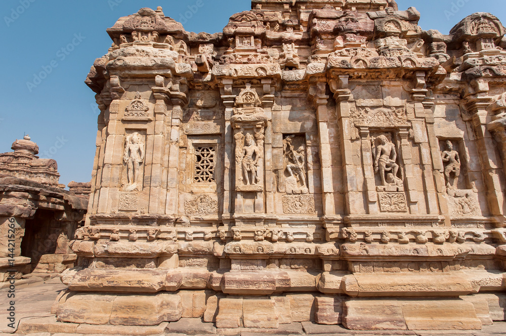 Walls with Indian design of stone relief on 7th century temples in Pattadakal of Karnataka, India. UNESCO World Heritage site with stone carved temples