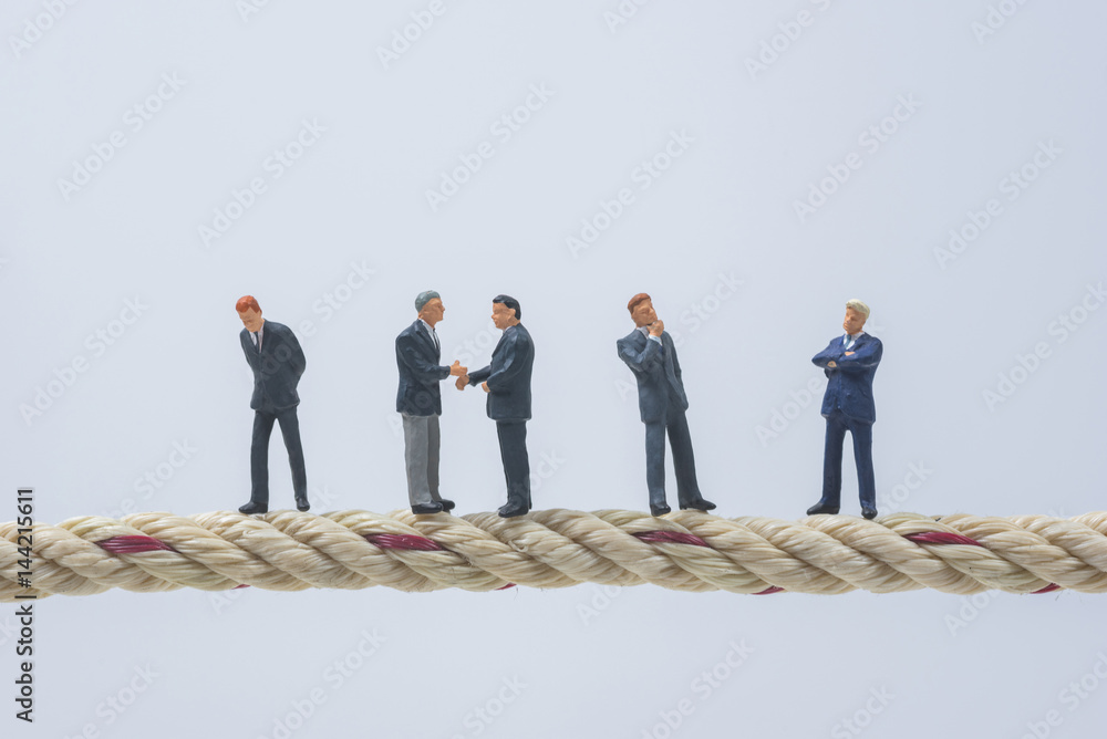 business miniature people standing on a rope business miniature people standing on a rope