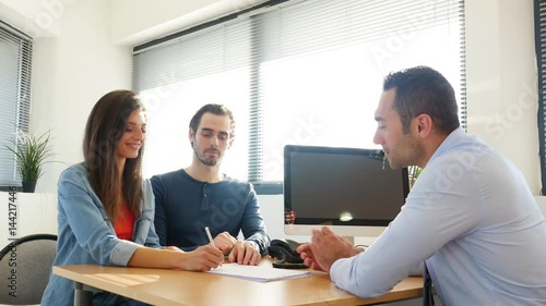Wallpaper Mural buying agreement contract signature and hand shaking between young couple and professional finance business man in office  Torontodigital.ca