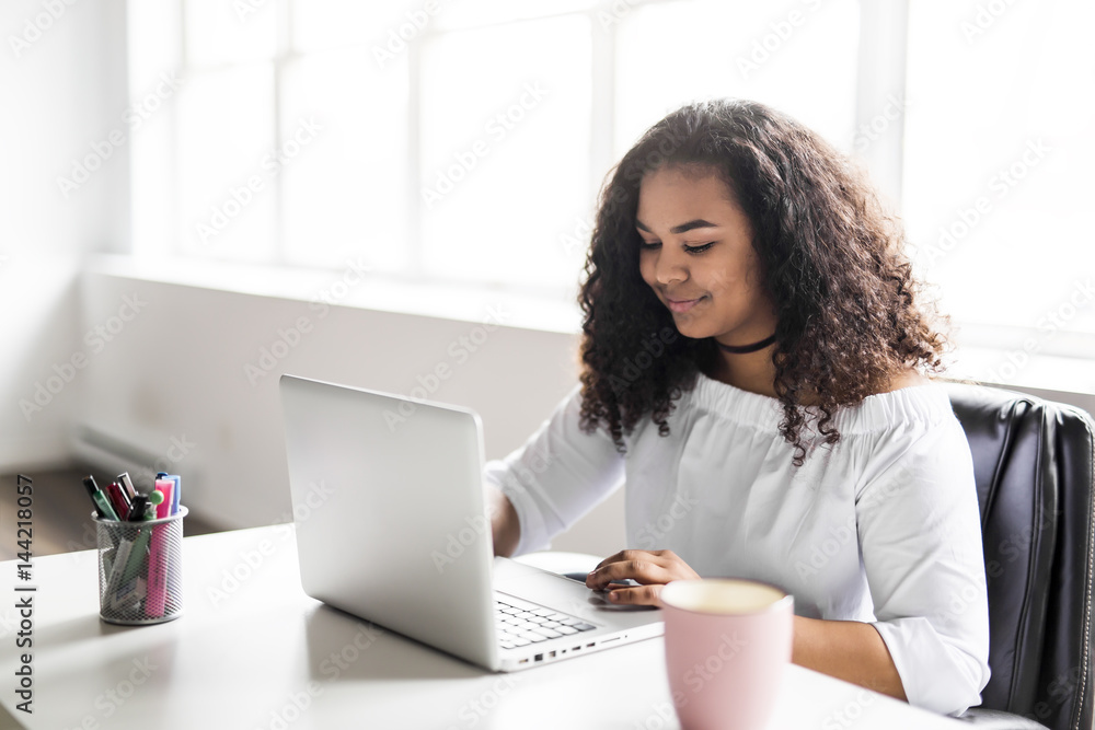 teen at desk in her office with laptop teen at desk in her office with laptop