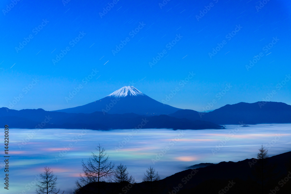 Fototapeta premium 雲海に浮かぶ富士山と雲に透ける街の灯り