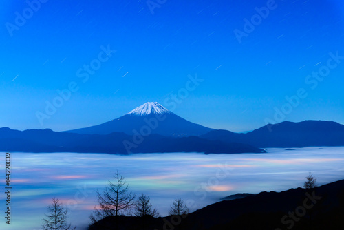 雲海に浮かぶ富士山と雲に透ける街の灯り