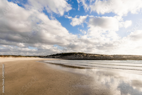 Beach, sand and reflection of sky in clear sea water. Summer season sunny day vacation concept 