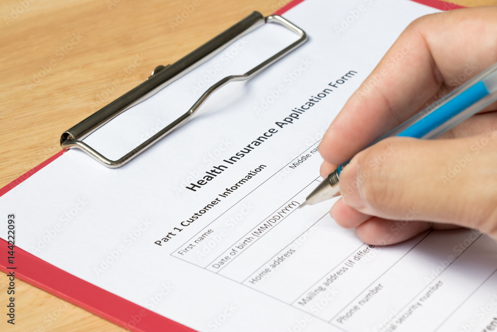 Health insurance application form with hand of patient fill data Health insurance application form with hand of patient fill data