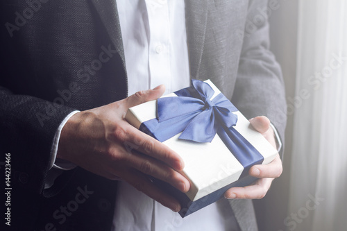 Fotografi Man offering gift with blue ribbon