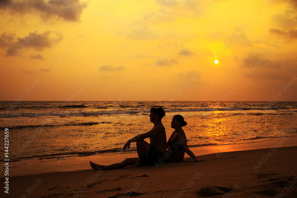 Obraz premium Silhouettes of a loving couple on the ocean shore.