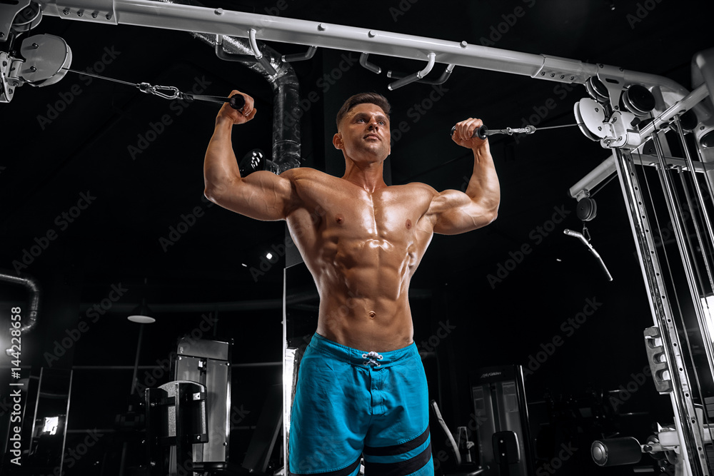 Young handsome guy doing exercises in the gym Young handsome guy doing exercises in the gym
