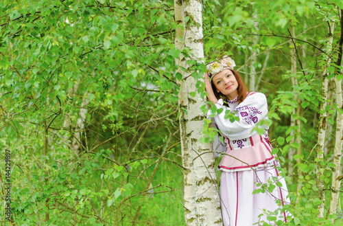 A beautiful girl in a national Belarusian costume against the backdrop of beautiful nature.