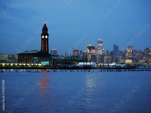 Hoboken Lackawanna clock tower, NJ transit, Path, light rail terminal and Midtown Manhattan in background at dusk photo