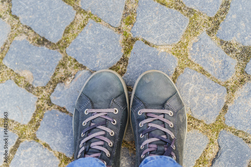 human legs standing on cobblestones