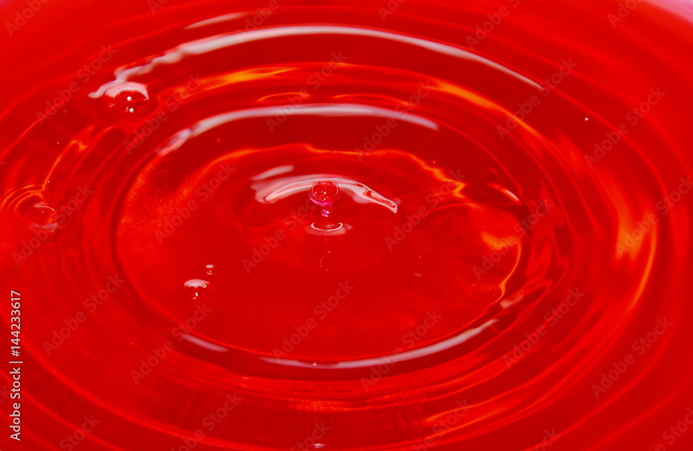 drop of water falling and splash on red background drop of water falling and splash on red background