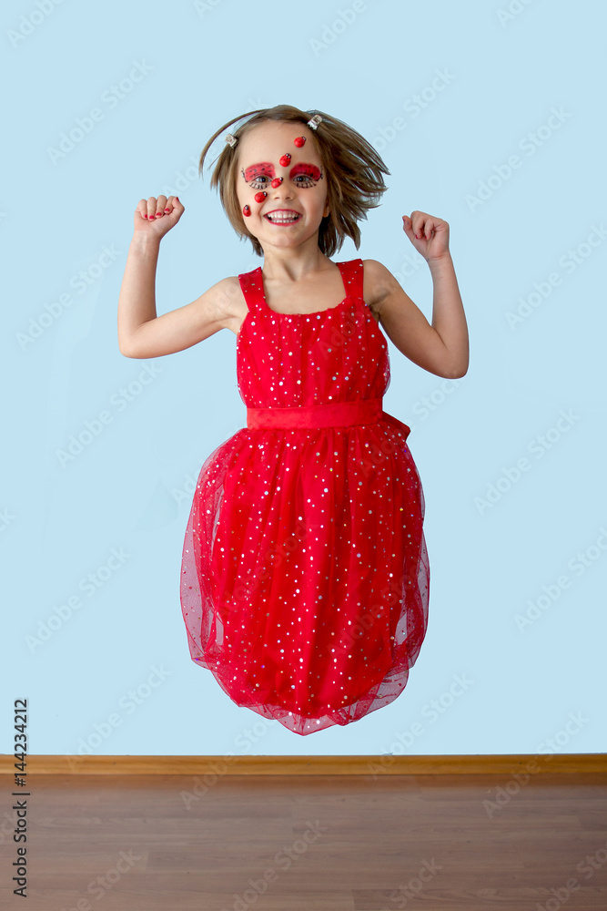 Naklejka premium Little girl with ladybug face paint jumping