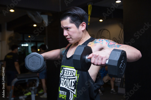 Handsome is a tattoo on his arm with muscle lifting a dumbbell. photo