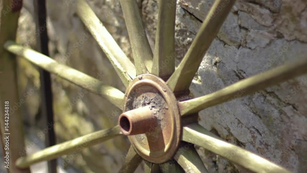 Old historic wagon wheel leaning against a stone wall Old historic wagon wheel leaning against a stone wall