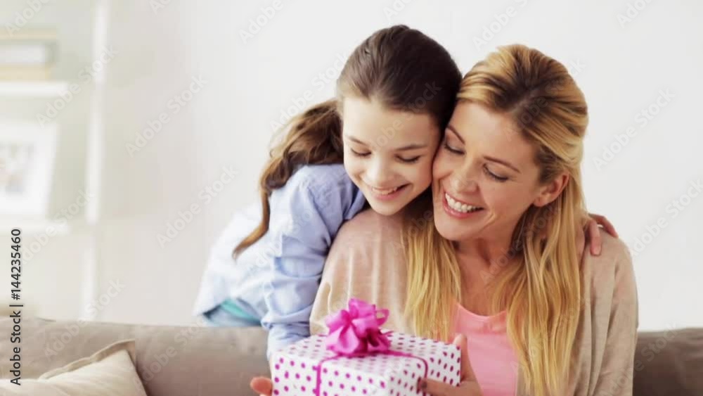 happy girl giving present to mother at home happy girl giving present to mother at home