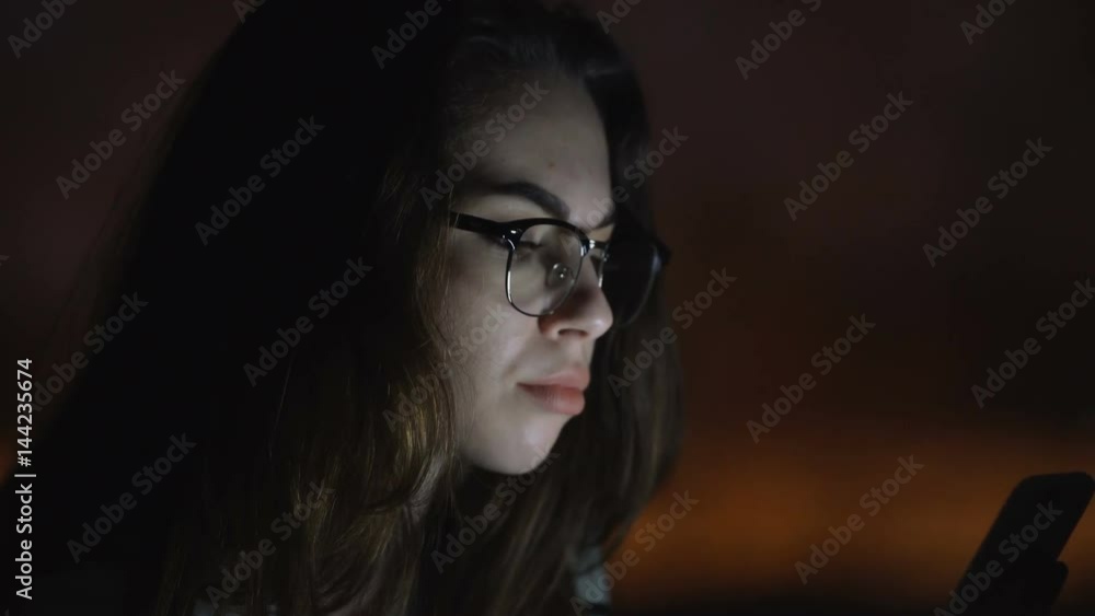 Unhappy young woman wearing glasses chatting using phone in office Unhappy young woman wearing glasses chatting using phone in office