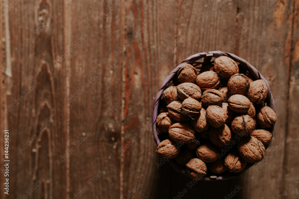 Whole walnuts on rustic old wooden floor, shot in natural light. Concept of healthy organic food. Whole walnuts on rustic old wooden floor, shot in natural light. Concept of healthy organic food.