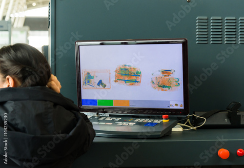 фотографія An X-ray monitor at airport and woman from security service.
