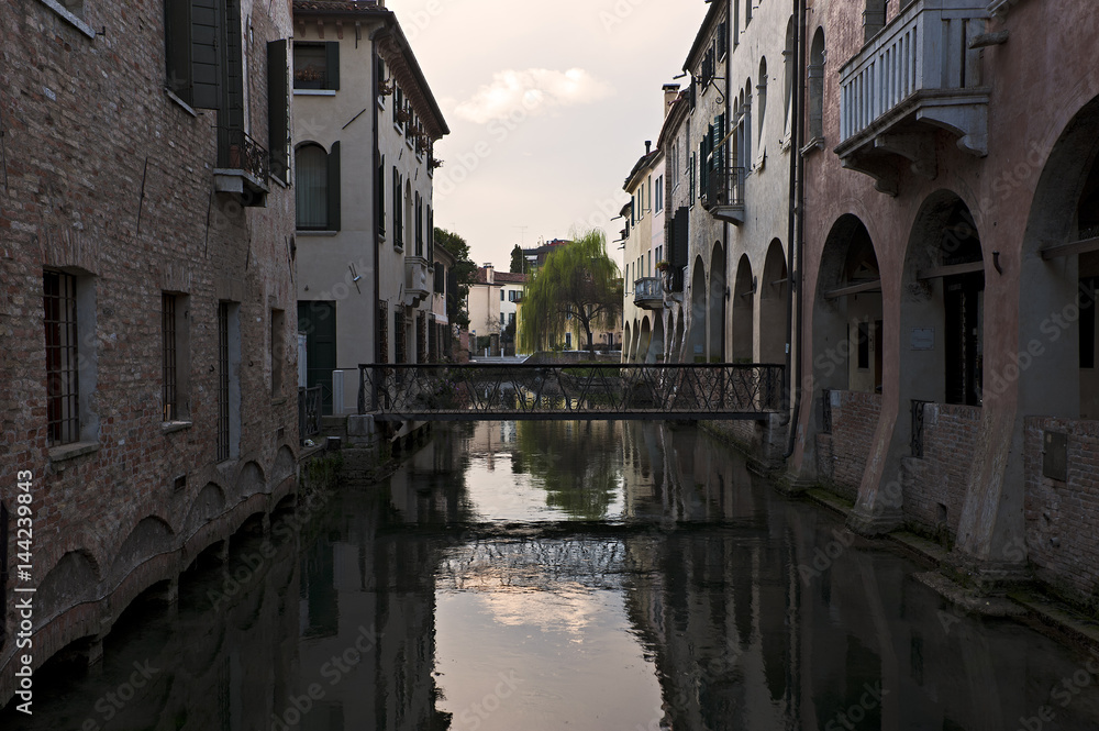 Reflections on Buranelli  canal at sunset in Treviso. Italy