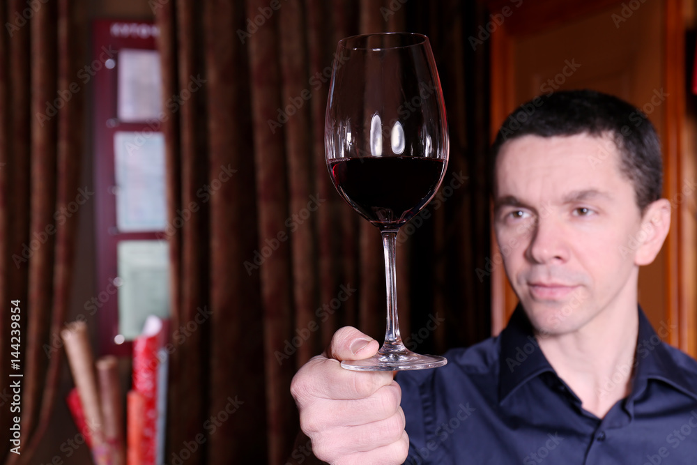 Handsome man holding glass of red wine