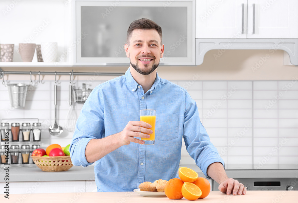 Handsome man with juice in kitchen Handsome man with juice in kitchen
