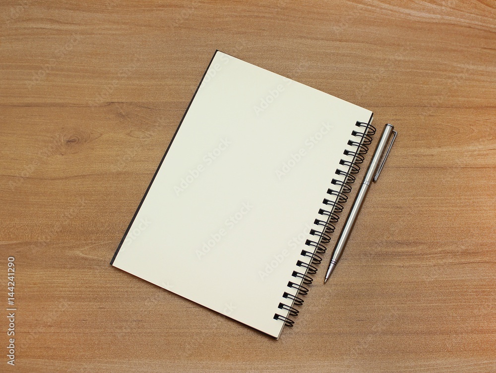 Notebook with white pages and pen on wooden table. Notebook with white pages and pen on wooden table.