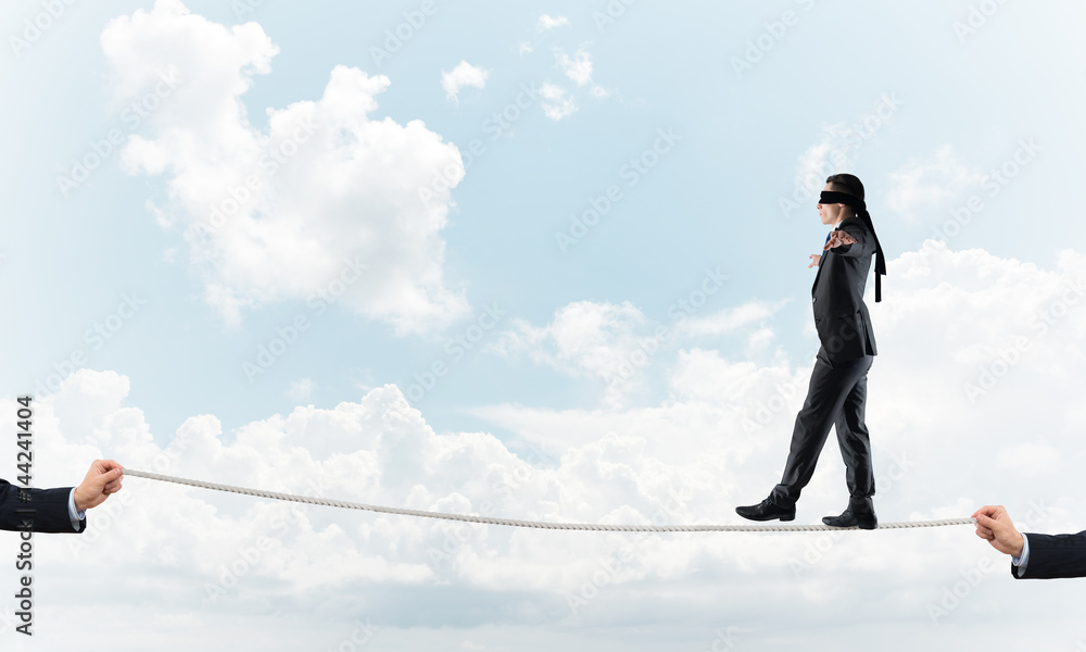 Business concept of risk support and assistance with man balancing on rope Business concept of risk support and assistance with man balancing on rope