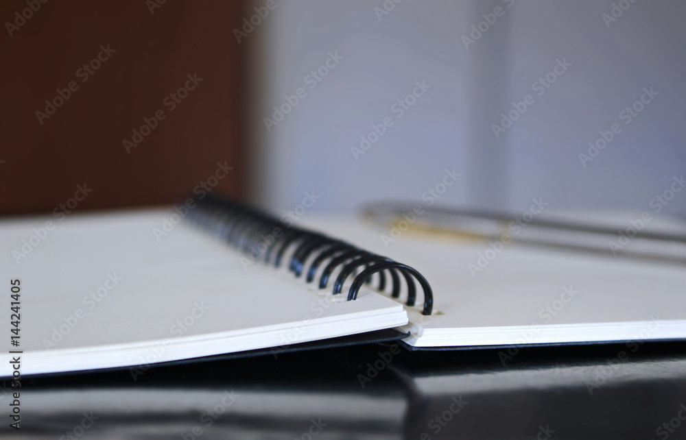 Notebook with white pages and pen on wooden table. Notebook with white pages and pen on wooden table.
