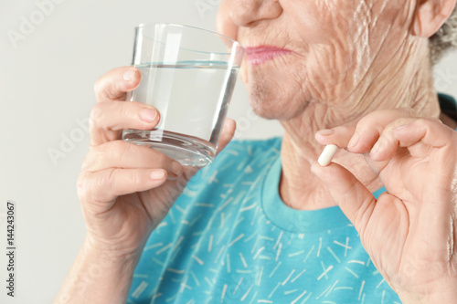 Elderly woman taking pill o...