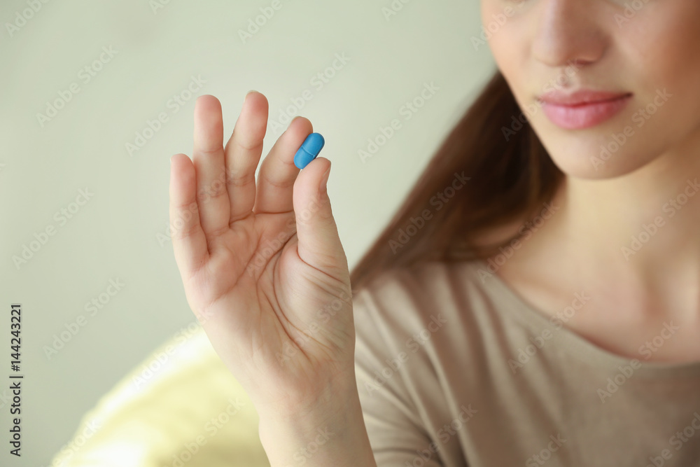 Beautiful young woman with pill, closeup Beautiful young woman with pill, closeup