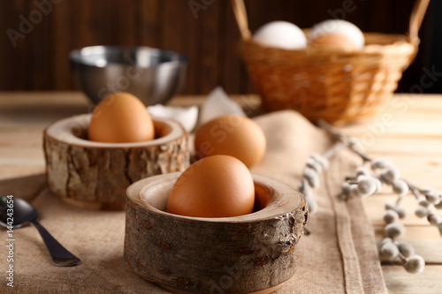Wooden stands with Ester eggs on linen tablecloth