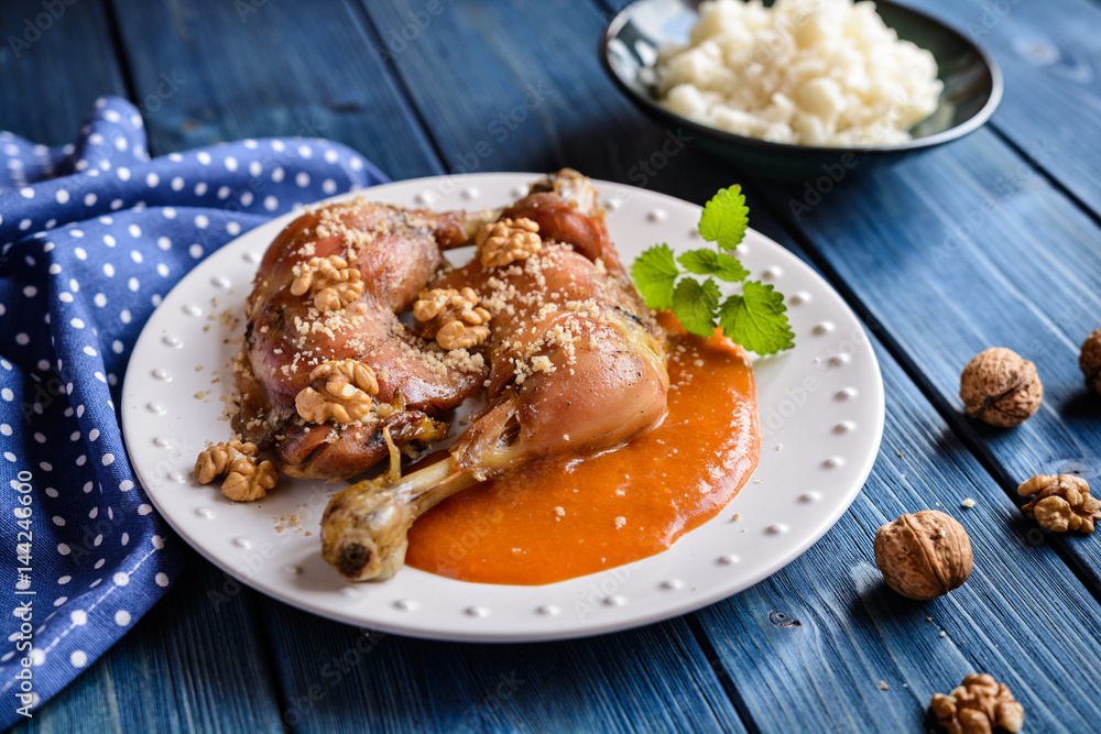 Roasted chicken thighs sprinkled with walnuts, served with apricot sauce and rice Roasted chicken thighs sprinkled with walnuts, served with apricot sauce and rice
