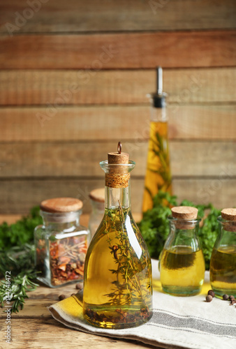 Olive oil with spices on wooden background
