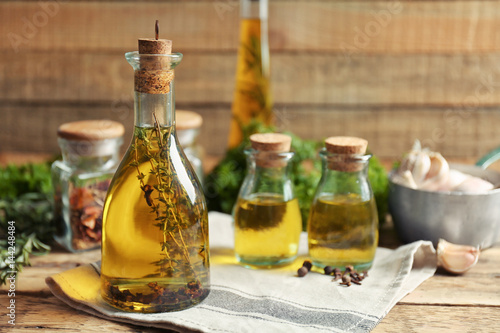 Olive oil with spices on wooden background
